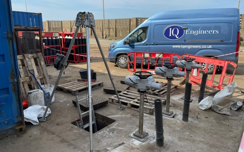 Sluice gate installation site with operating gear and tripod hoist, managed by IQ Engineers.