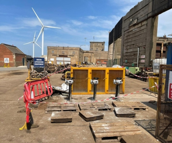 Dockside sewer infrastructure installation with sluice gate actuators and safety barriers